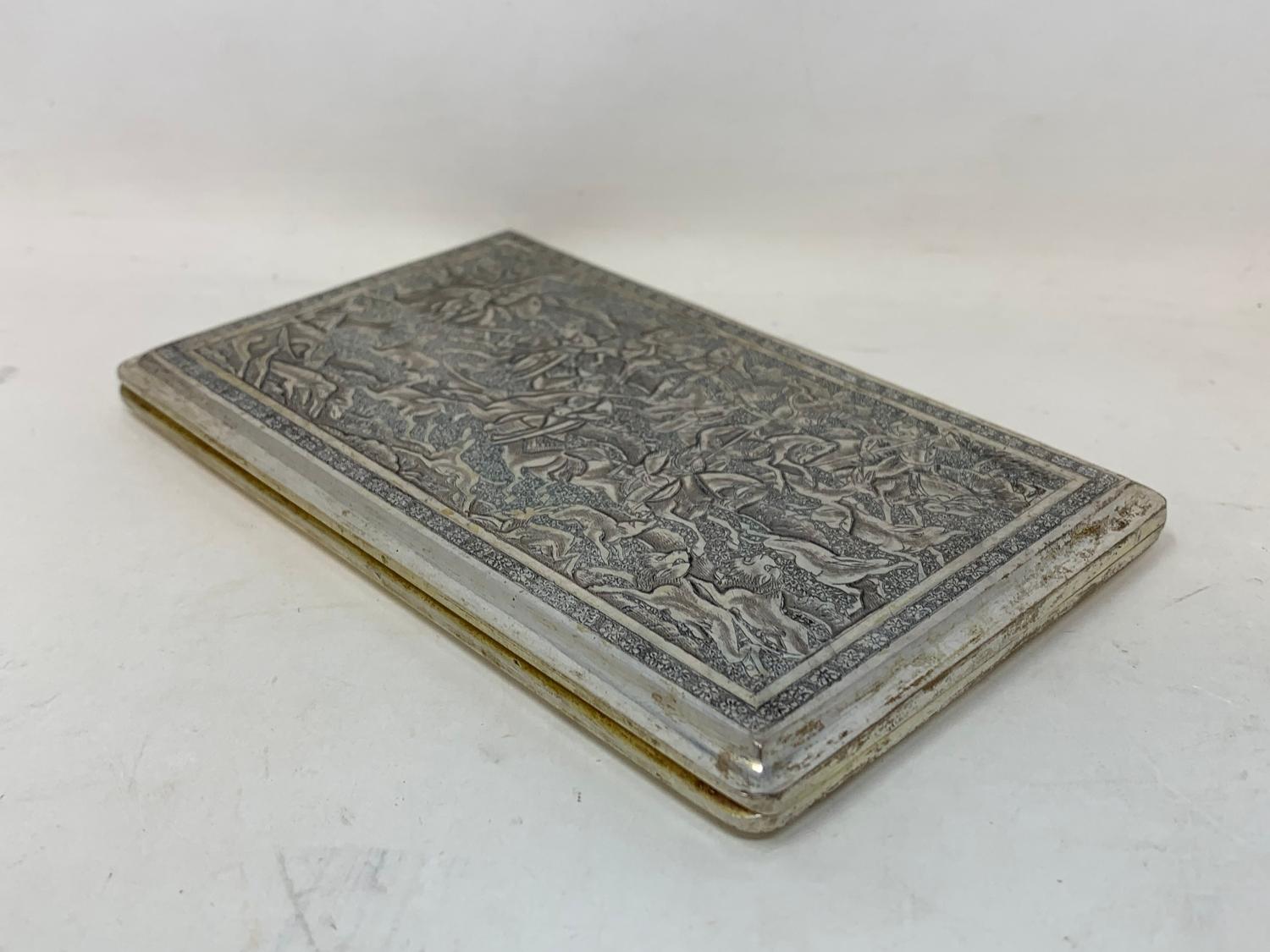 A Persian silver coloured metal cigarette case, decorated figures on horseback hunting lions and - Image 3 of 6