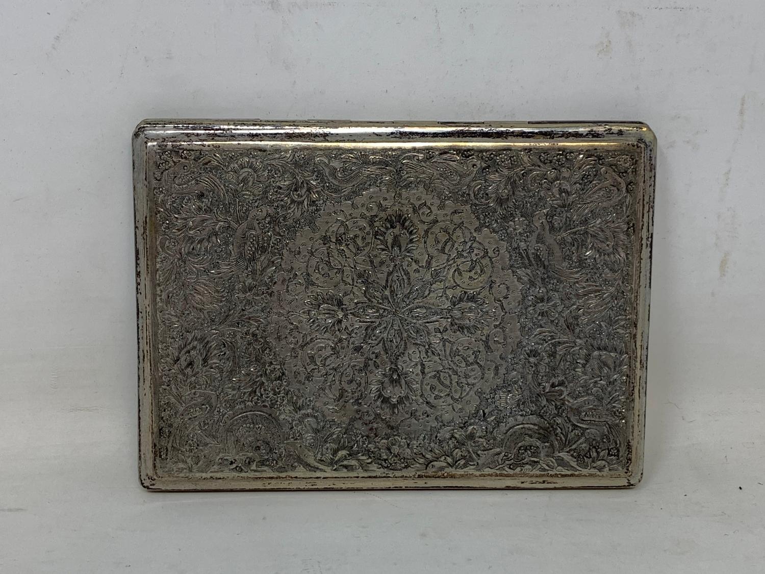 A Persian silver coloured metal cigarette case, decorated birds, flowers and foliage, 11.5 cm wide