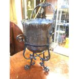 An Arts & Crafts copper jardinière, on a wrought iron frame with a swing handle, 66 cm high