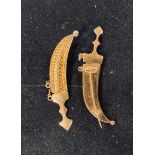 A pair of yellow coloured metal brooches, in the form of Jambiya, with detachable knives from the