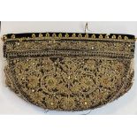 An Indian velvet cap, with gold thread decoration applied gems, 27.5 cm wide See illustration