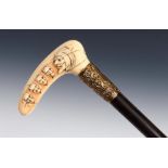 A 19th century walking stick, with an L shaped ivory handle carved Mephistopheles and four other