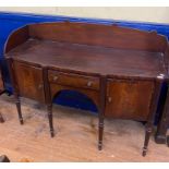 An early 19th century Irish mahogany sideboard, the three quarter gallery back above a central