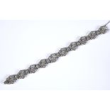 An Art Deco style white coloured metal and diamond fancy link bracelet, 16.5 cm