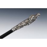 A slender 19th century walking cane, the Continental silver coloured metal handle in the form of a