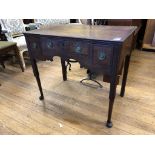 A George III oak lowboy, crossbanded in mahogany, having three drawers above a shaped apron, on