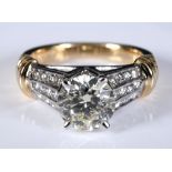 A 14ct gold ring, central diamond of approx. 1.90ct, with three rows of channel set diamonds,