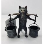 A modern novelty match strike in the form of a cat carrying two buckets, 10 cm high This item is