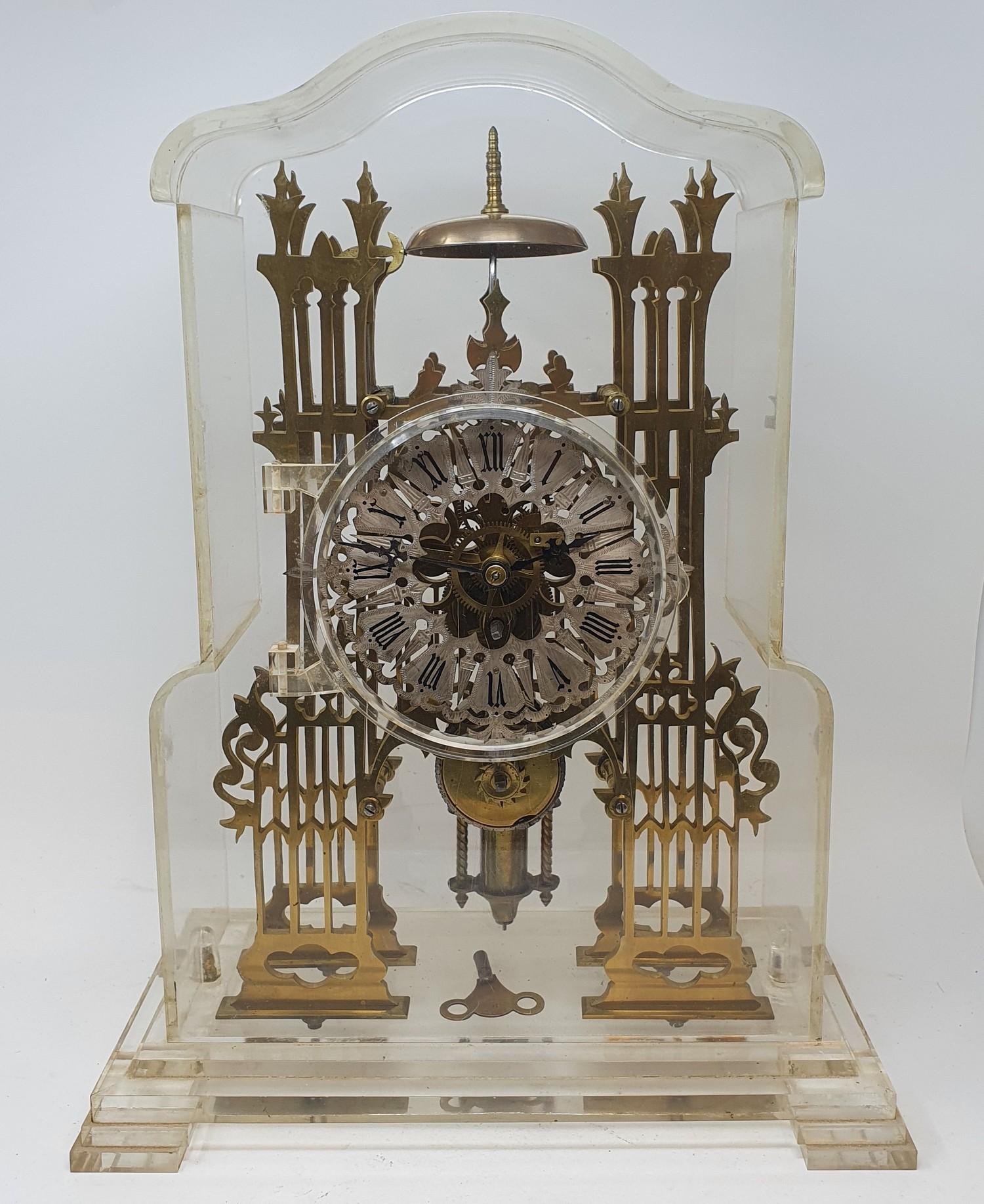 A brass skeleton clock, the silvered chapter ring with Roman numerals, fitted a single fusee