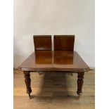 An early Victorian mahogany extending dining table, on reeded baluster legs, 130 x 116 cm, with