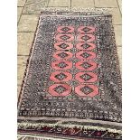 A persian type pink ground rug, 180 x 130 cm, various losses to the pile, and a cream ground rug,