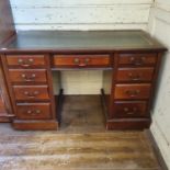 A mahogany kneehole desk, having a gilt tooled leather inset top, and a base with nine drawer