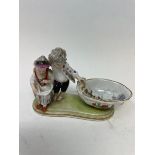 A Meissen figural salt, the bowl interior painted figures and ships, 15 cm wide She is missing the