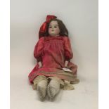 A late 19th century bisque head and shoulder doll, 50 cm high