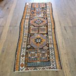 A Persian runner, multiple borders, centered with repeating geometric medallions, 89 x 226 cm, a