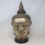 A large brass Buddha head, on a stand, 46 cm high