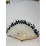 A late 19th century Chinese carved ivory fan, with feathers, 30 cm, and four others similar, all