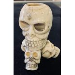 A bone candlestick, carved skulls, 7 cm high Modern