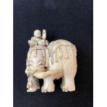 An early 20th century carved ivory elephant with three attendants, one detached, some loss, two