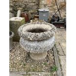 A composition stone garden urn, decorated leaves, on square foot, 68 cm diameter