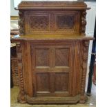 A late 19th century Anglo-Flemish oak cabinet, the raised back above a panel door, carved all over