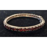 A silver and garnet bangle Modern