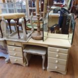 A painted dressing table, 134 cm wide, a pair of painted tables, a triptych mirror, a stool, a