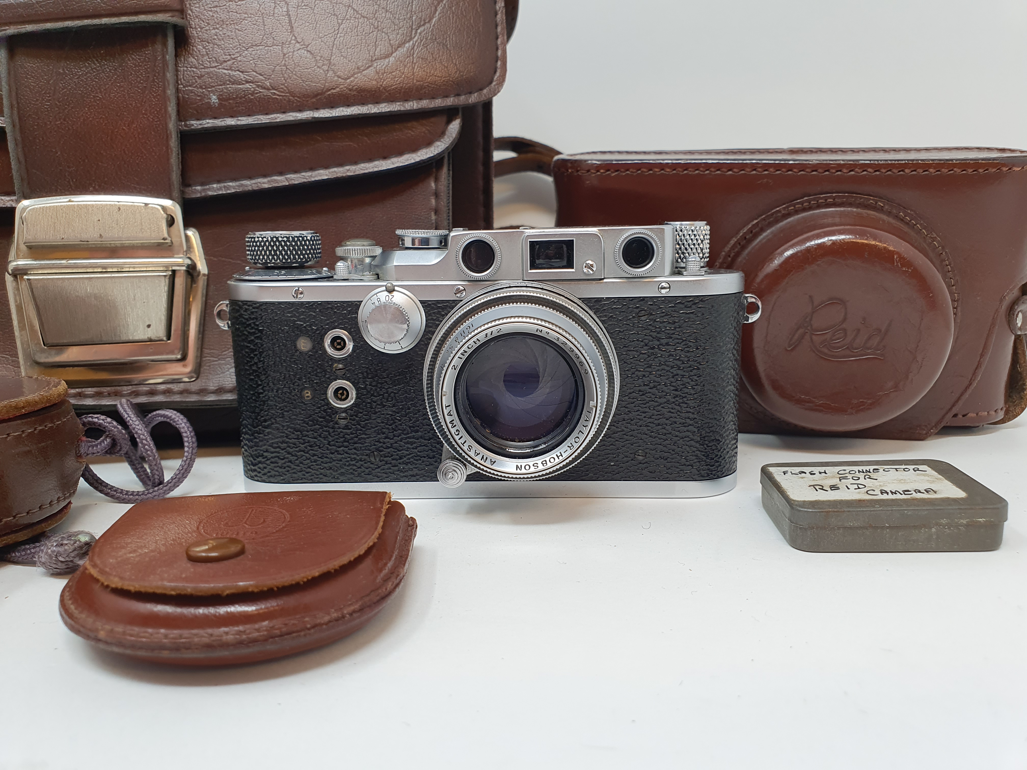A Reid & Sigrist ltd camera, serial number P2750, with leather outer case, lens, and accessories