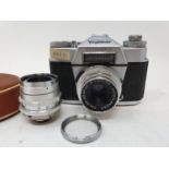 A Voigtlander Bessamatic camera, with leather outer case, a lens, other items and a camera box