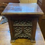 A stool, the elm top on an oak base with gothic carved decoration, 33 cm wide
