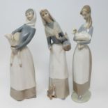 A Lladro figure of a lady with a puppy, 28 cm high, three other Lladro figures, a Royal Copenhagen