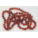 A string of 107 amber beads, 145 cm long (over clasps)