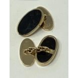 A pair of 9ct gold and onyx oval cufflinks