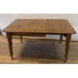 A 19th century mahogany extending dining table, on turned tapering legs to casters?, with one