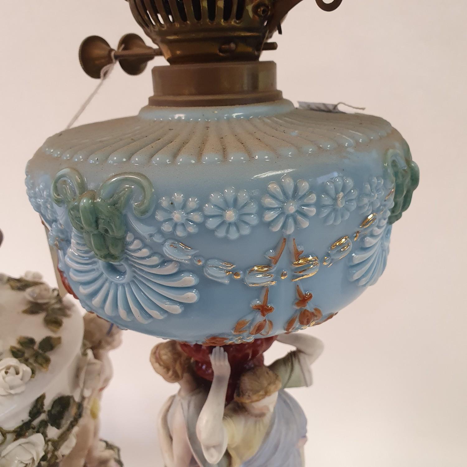 A Dresden porcelain oil lamp, flower encrusted well raised by three putti, 55 cm high, and an oil - Image 5 of 11