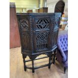 An 18th century style oak cupboard, with pierced doors, raised on turned carved legs, 90 cm wide