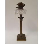 A brass oil lamp, with a cut glass well, base in form of a corinthian column, 56 cm high