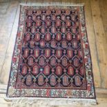 A Persian red ground rug, main cream border, centre with repeating geometric forms, 174 x 123 cm