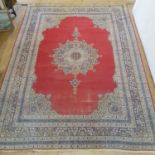 A Persian red ground carpet with multiple borders, centre with shaped medallion, 370 x 280 cm
