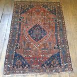 A Persian red ground rug, multiple borders, centre decorated with foliate forms, 183 x 125 cm