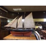 A large painted wood model of a schooner, the Fruit Girl out of Gurnsey, rigging loose, surface