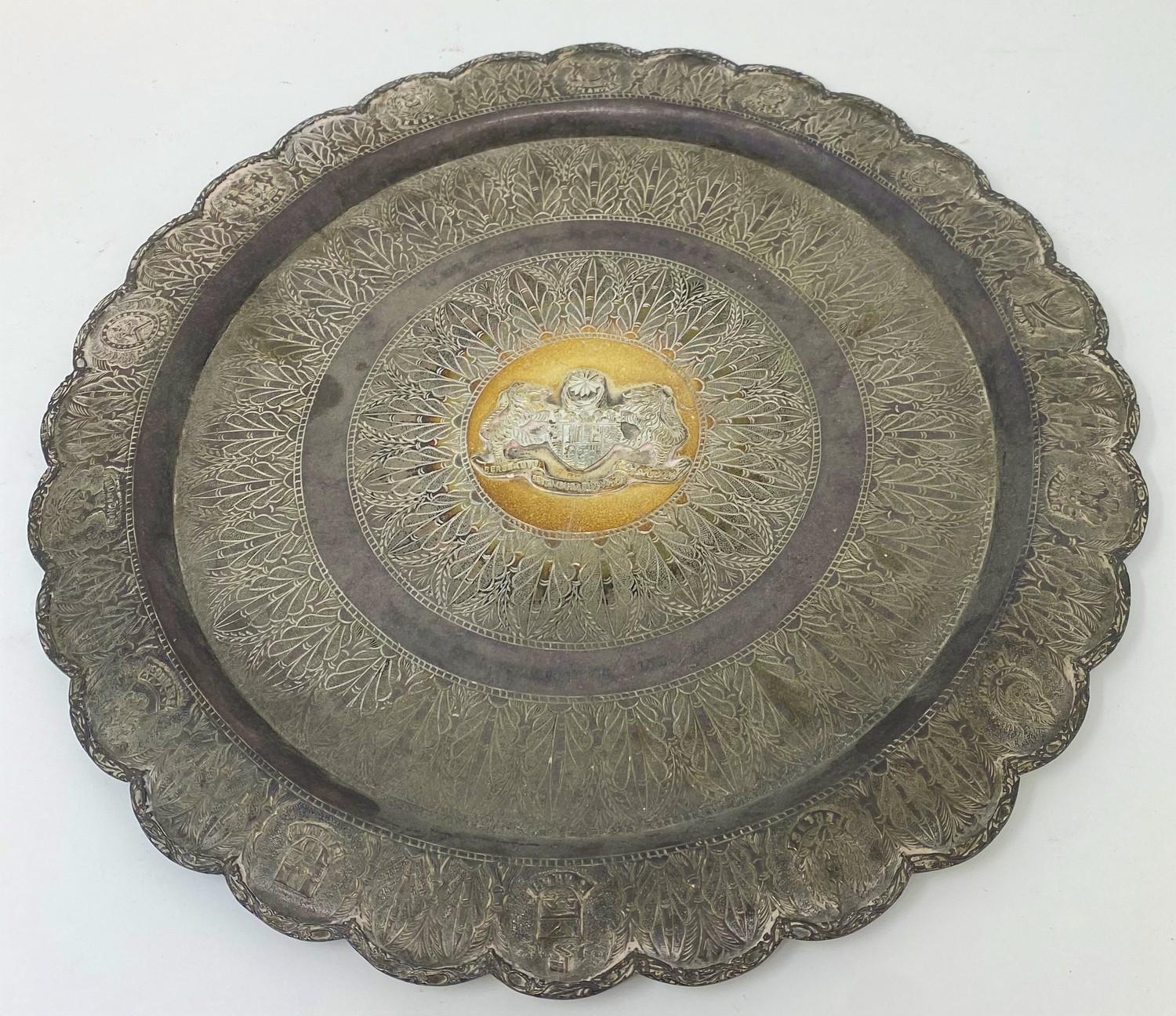 A Malaysian silver coloured metal tray, the centre applied an armorial inscribed with a presentation