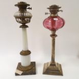 A silver plated oil lamp, with a cranberry glass well, 56 cm high, and an opaque glass oil lamp,