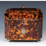An early 19th century tortoiseshell tea caddy, with silver coloured metal mounts, hinged to reveal