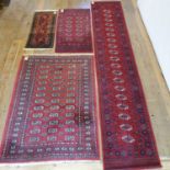 A red ground runner, 382 x 70 cm, a red ground rug, 117 x 51 cm, a red ground rug, 137 x 70 cm,