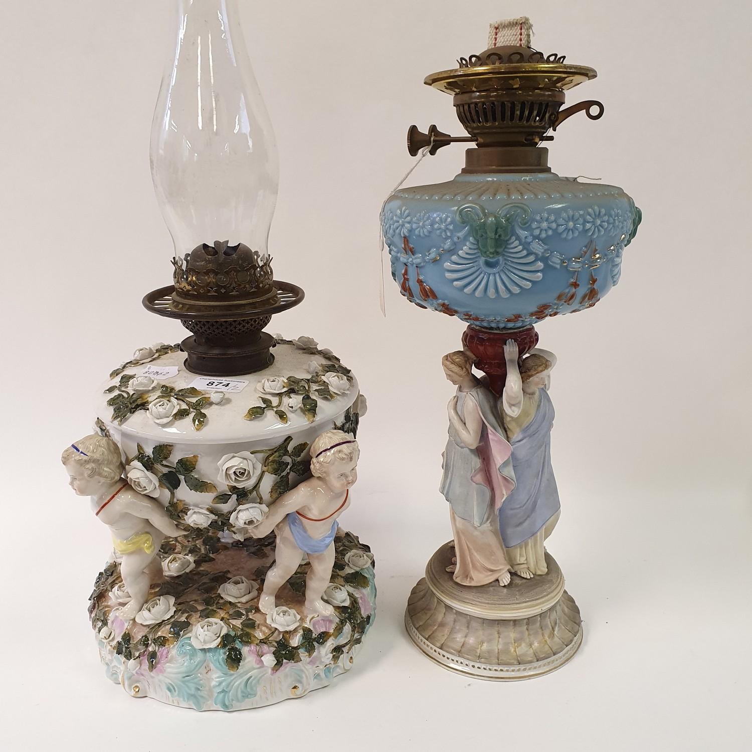 A Dresden porcelain oil lamp, flower encrusted well raised by three putti, 55 cm high, and an oil