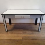 A 1920s white and black enamel table, with a single drawer, 145 cm wide