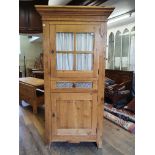 A modern oak pantry cupboard, with glazed door, above a drawer, above a cupboard door, 197 cm