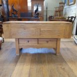 A modern oak kitchen table, with drop leaves, on square legs united by an under tier with two