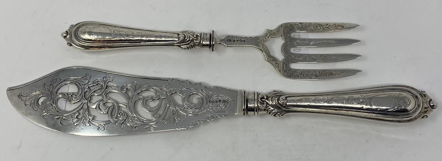 A pair of Victorian silver fish servers, handles loaded, Birmingham 1855